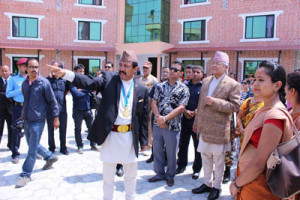 Basanta Kunwar con el Viceprimer Ministro delante del nuevo edificio de rehabilitación