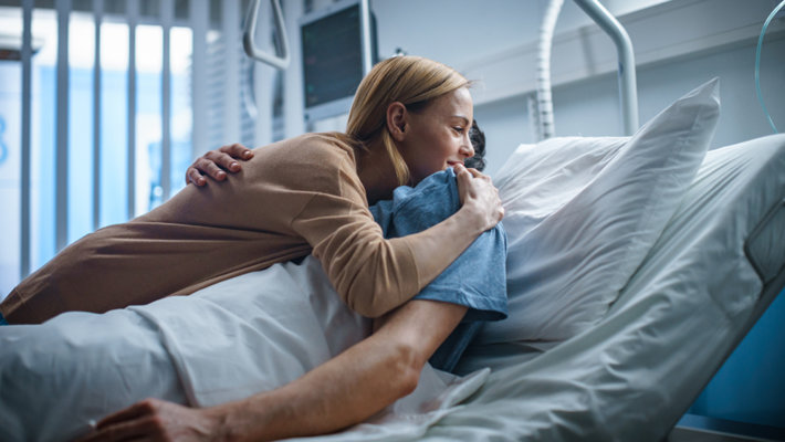 Wife hugs husband in hospital