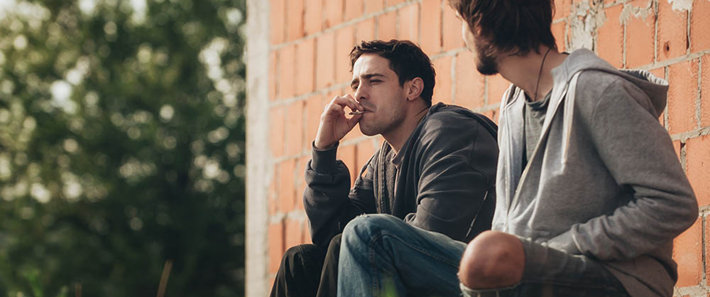 two young men smoking a joint
