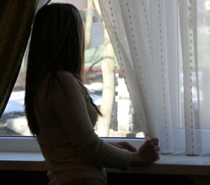 depressed woman looking out window
